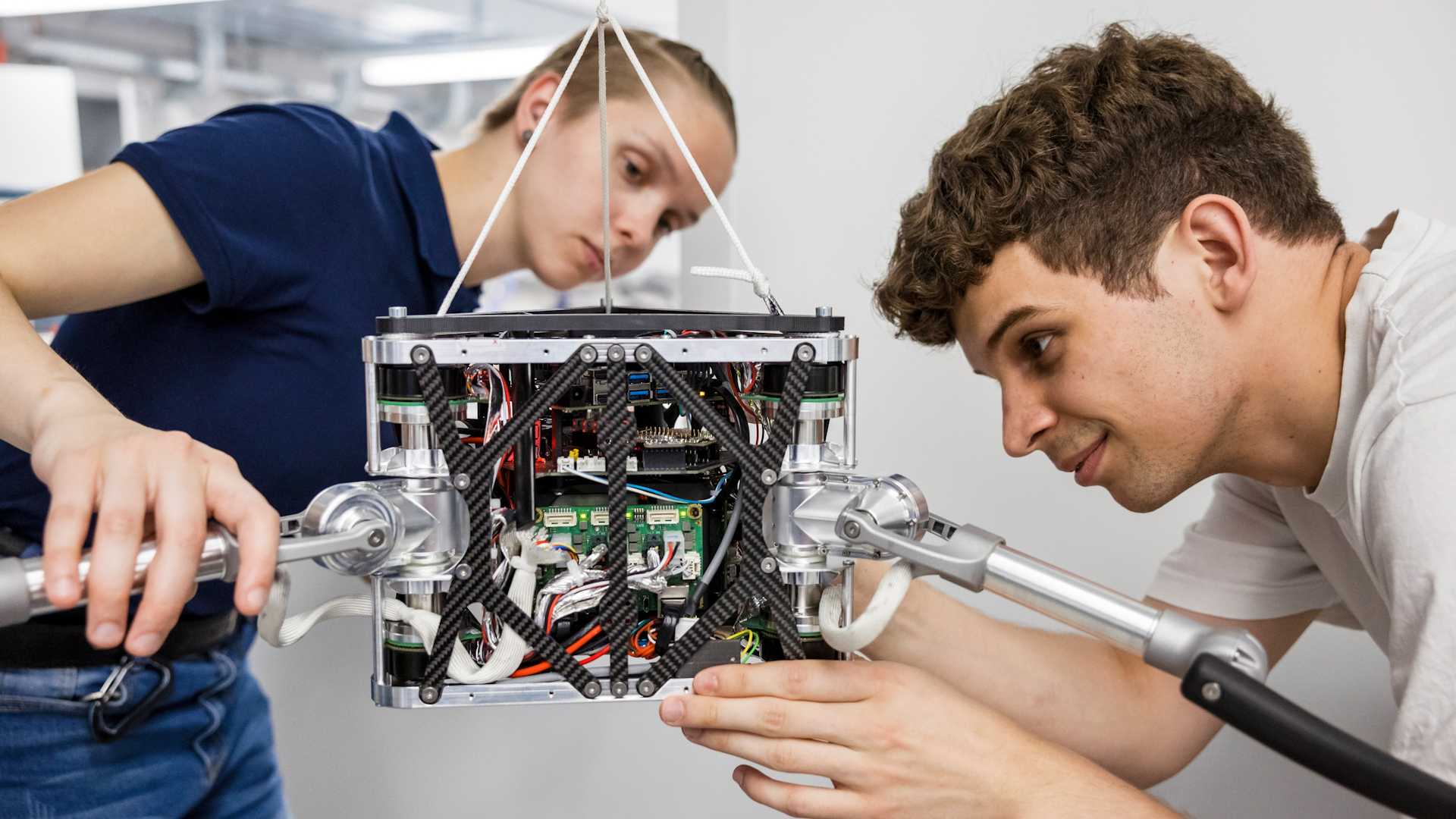 Vergrösserte Ansicht: Studentin und Student arbeiten gemeinsam an einer Drohne